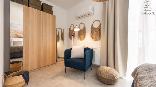 a bedroom with a blue chair and a bed at Flatbook Apartamenty - Mikoszewo Wczasowa I in Nickelswalde