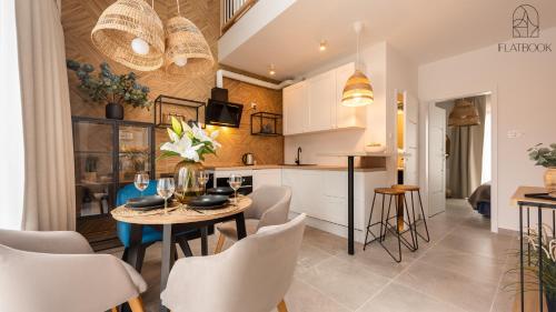 a kitchen and dining room with a table and chairs at Flatbook Apartamenty - Mikoszewo Wczasowa I in Nickelswalde