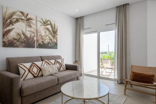 a living room with a couch and a glass table at Quinta de Bela-Mandil in Olhão