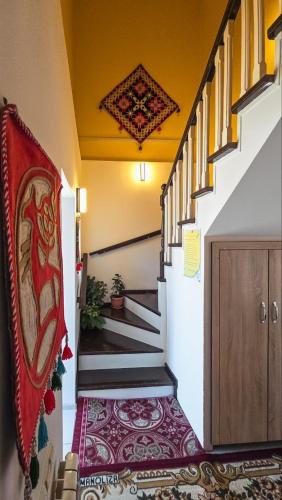 a hallway with stairs with a rug on the floor at Guest House Nur in Kochkor