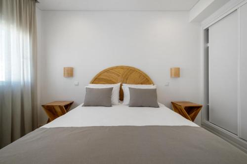 una camera da letto con un letto grande con testiera in legno di Quinta de Bela-Mandil a Olhão