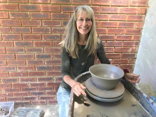 a woman holding a bowl on a wheel at Sani Lodge & Cottages in Sani Pass