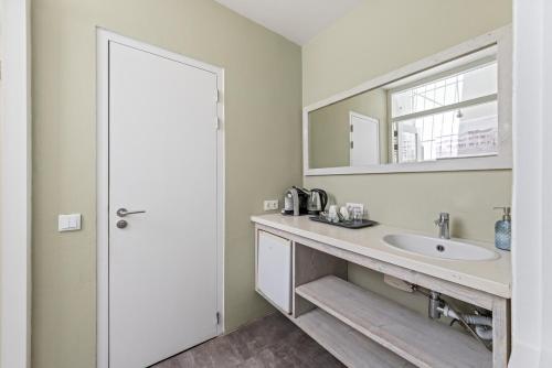 a bathroom with a sink and a mirror at Boutique Hotel 't Klooster in Willemstad