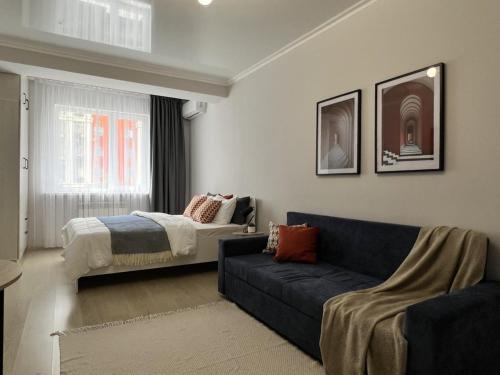 アルマトイにあるЖК Молодежныйのソファとベッドのあるリビングルーム