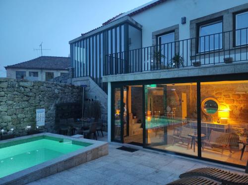 a house with a swimming pool next to a building at Aquénio do Ouriço in Sernancelhe