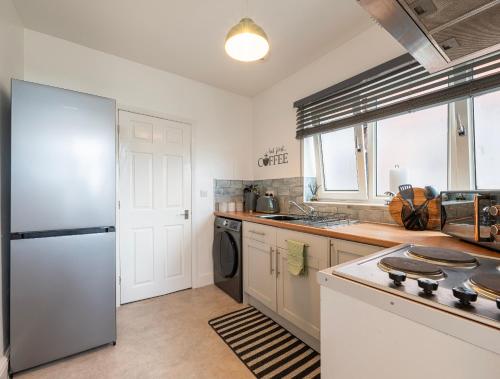 a kitchen with a refrigerator and a stove top oven at Urban Hideaway in Canwick