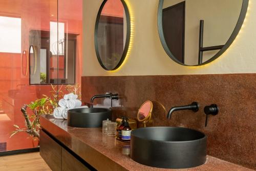 ein Badezimmer mit zwei Waschbecken und zwei Spiegeln in der Unterkunft Five Stories Villas By SUOM in Canggu