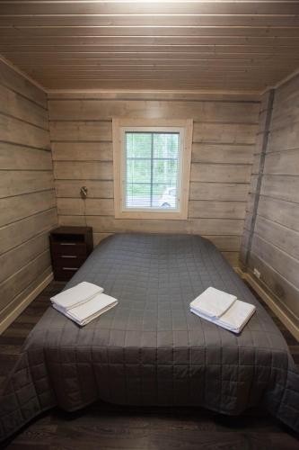a bed in a small room with a window at SResort Saunas - hot tub, palju in Imatra