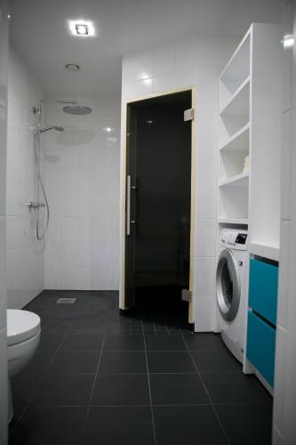 a bathroom with a toilet and a washing machine at Pärnu Lubja Apartments in Pärnu