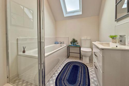 a bathroom with a tub and a toilet and a sink at Stylish apartment in Portstewart in Moffat