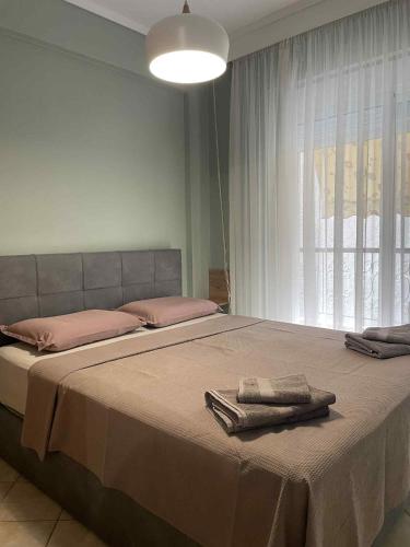 Un dormitorio con una cama grande con dos toallas encima. en The Cozy Central Home, en Xanthi
