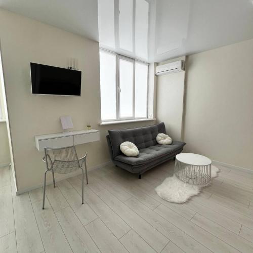 a living room with a couch and a table at A cozy and bright studio apartment in Chornomorsk