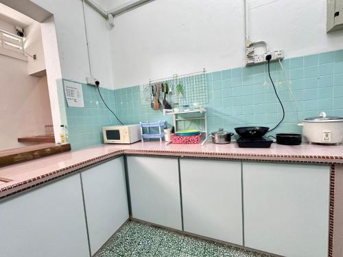 a kitchen with white cabinets and blue tiles at 26 Rangoon Residence 26 in George Town