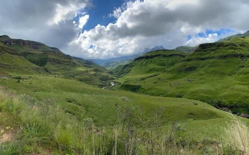 a view of a valley in a green mountain at Sani Lodge & Cottages in Sani Pass