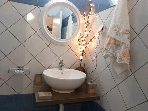 a bathroom with a white sink and a mirror at Adelia's Luxury Studio in Corfu in Corfu