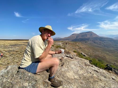 a man sitting on a rock on a mountain at Sani Lodge & Cottages in Sani Pass