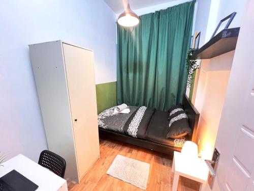 Piccola camera con letto con tenda verde di Amour Room For Couple in Barsha Heights Tecom a Sabkhah