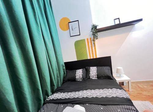 una camera con letto e tenda verde di Amour Room For Couple in Barsha Heights Tecom a Sabkhah