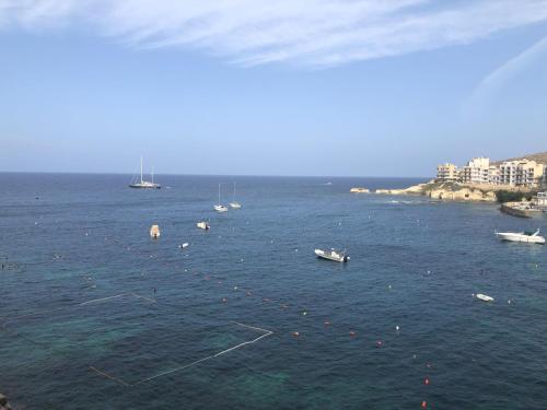 a large body of water with boats in it at Wake up to the gorgeous sunrise in Marsalforn