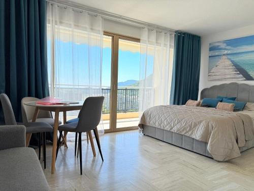 - une chambre avec un lit et une table avec vue dans l'établissement My Resid Appart Cannes marina vue mer, à Mandelieu-la-Napoule