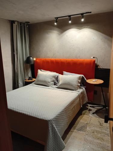 un letto con testiera arancione in una stanza di Flatpremium1501 a Fortaleza