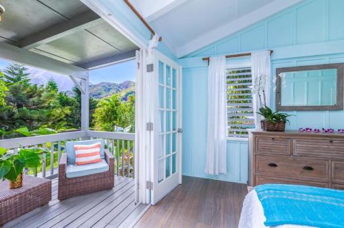 a blue bedroom with a bed and a balcony at Hale Kanani (Kaua'i) TVNC 1342 in Hanalei