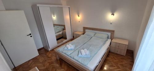 a small bedroom with a bed and a mirror at Apartman OZ II in Bihać