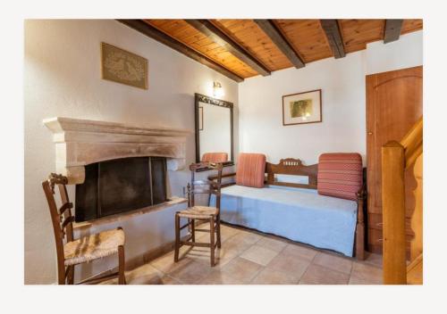 a room with a fireplace and a bed and chairs at Goulas Traditional Guesthouse in Monemvasia