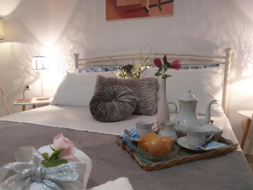 a bed with a tray of food and flowers on it at Adelia's Luxury Studio in Corfu in Corfu