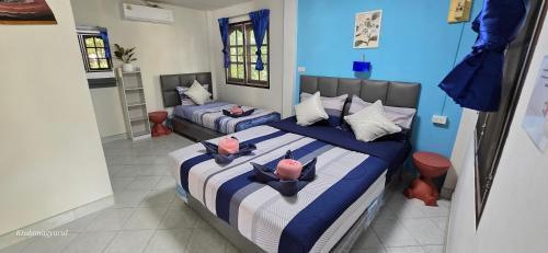a bedroom with two beds with hats on them at Sabai Resort in Ao Nang Beach
