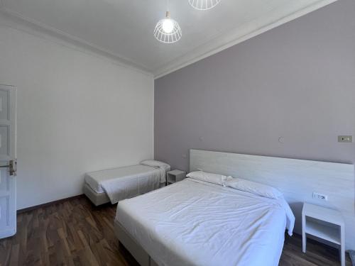a white bedroom with two beds and a table at Green Park San Pancrazio in Rome