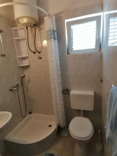 a small bathroom with a toilet and a sink at Apartman Dide in Igrane