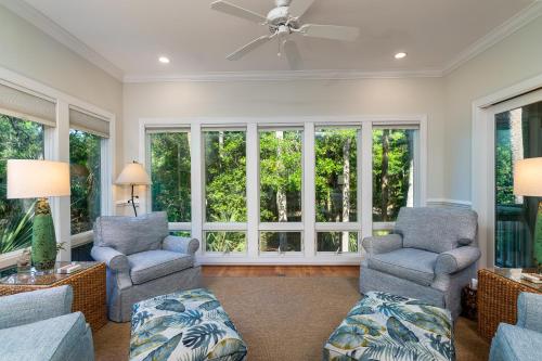 a living room with two chairs and windows at 1006 Crooked Oaks in Seabrook Island