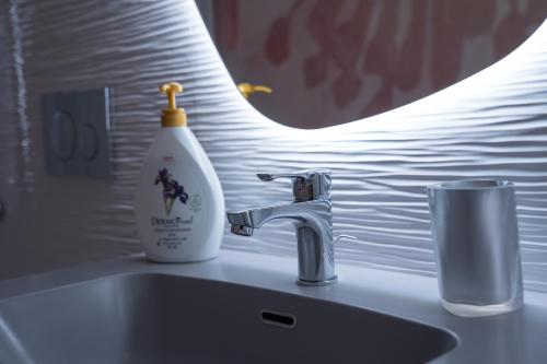 un lavandino in bagno con una bottiglia di sapone accanto a uno spazzolino da denti di Dimora Santi e Marinai a Bari