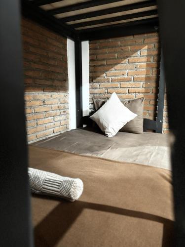 a bed in a room with a brick wall at PaddyView by Zzz in Banyuwangi