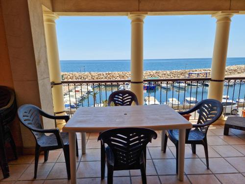 a table and chairs on a balcony with the beach at Puerto13 amanecer mediterráneo in Villaricos