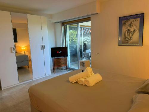 - une chambre avec un lit et des serviettes jaunes dans l'établissement Marilyn Beach - Vue mer, terrasse, garage privé, à Cannes