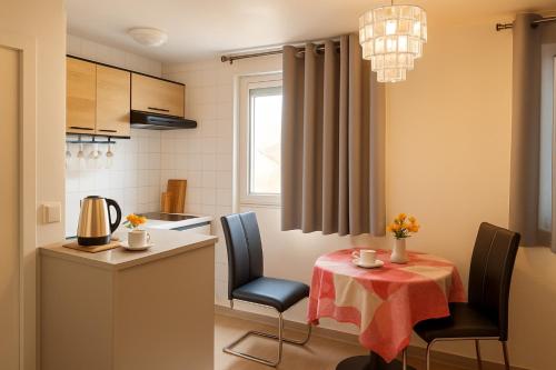 a kitchen with a table and chairs and a small table with a tablecloth at Week-end Porte de Clichy in Clichy