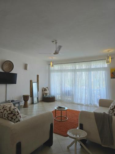 a living room with two couches and a table at OceanClose 1&2 Bedroom Malindi in Malindi