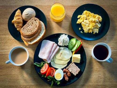 un tavolo con due piatti di prodotti per la colazione e caffè di VisitZakopane - Radowid Loft Spa Apartment a Zakopane