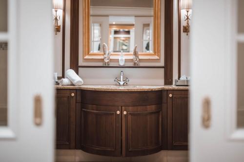 a bathroom with a sink and a mirror at Majestic - Unique Spa Resort in Brunico