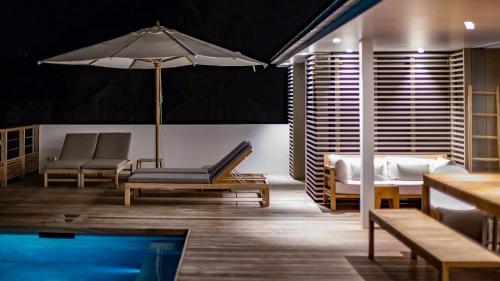 a hotel room with a pool and a bed and an umbrella at Four-Bedroom Sunset Villa with Infinity Pool in Pointe Milou