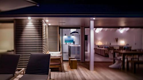 a room with chairs and a table and a kitchen at Four-Bedroom Sunset Villa with Infinity Pool in Pointe Milou