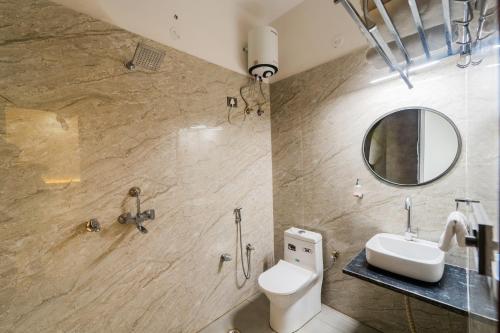 a bathroom with a toilet and a sink and a mirror at Hotel Kanha & Banquet in Mohāna