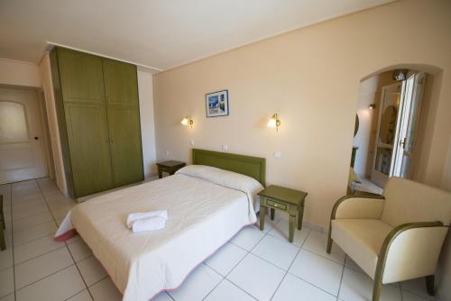 a bedroom with a bed and a couch and a chair at Hotel Niras in Nydri