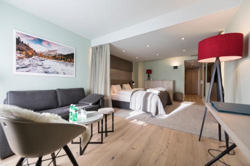 a hotel room with a bed and a couch and a table at Hotel Rosatsch in Pontresina