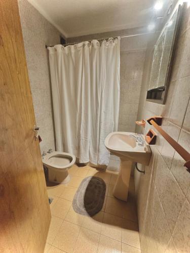 a bathroom with a toilet and a sink and a shower at Marcelinos la perla in Mar del Plata