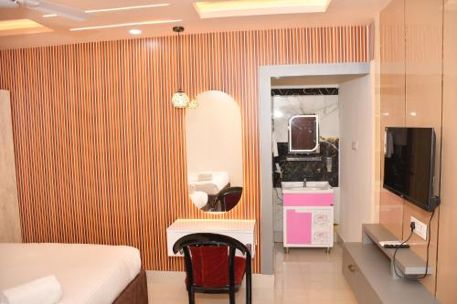 a hotel room with a bed and a mirror at Hotel Ratneswar in Alīpur Duār
