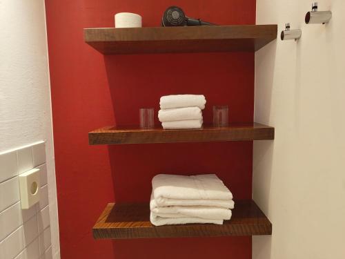 a bathroom with wooden shelves with towels on them at WHLIVING - Apartments & Studios in Konstanz in Konstanz