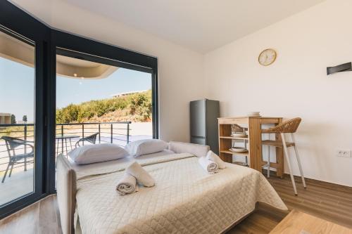 Un dormitorio con una cama y una ventana grande. en SeaSide Luxury Apartments, en Ulcinj